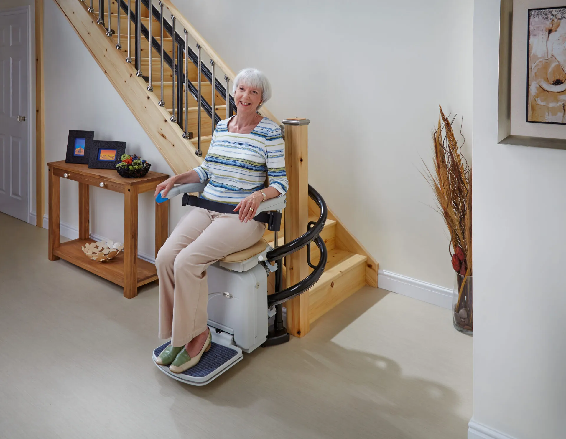 Woman riding a curved stairlift comfortably in her Motherwell home