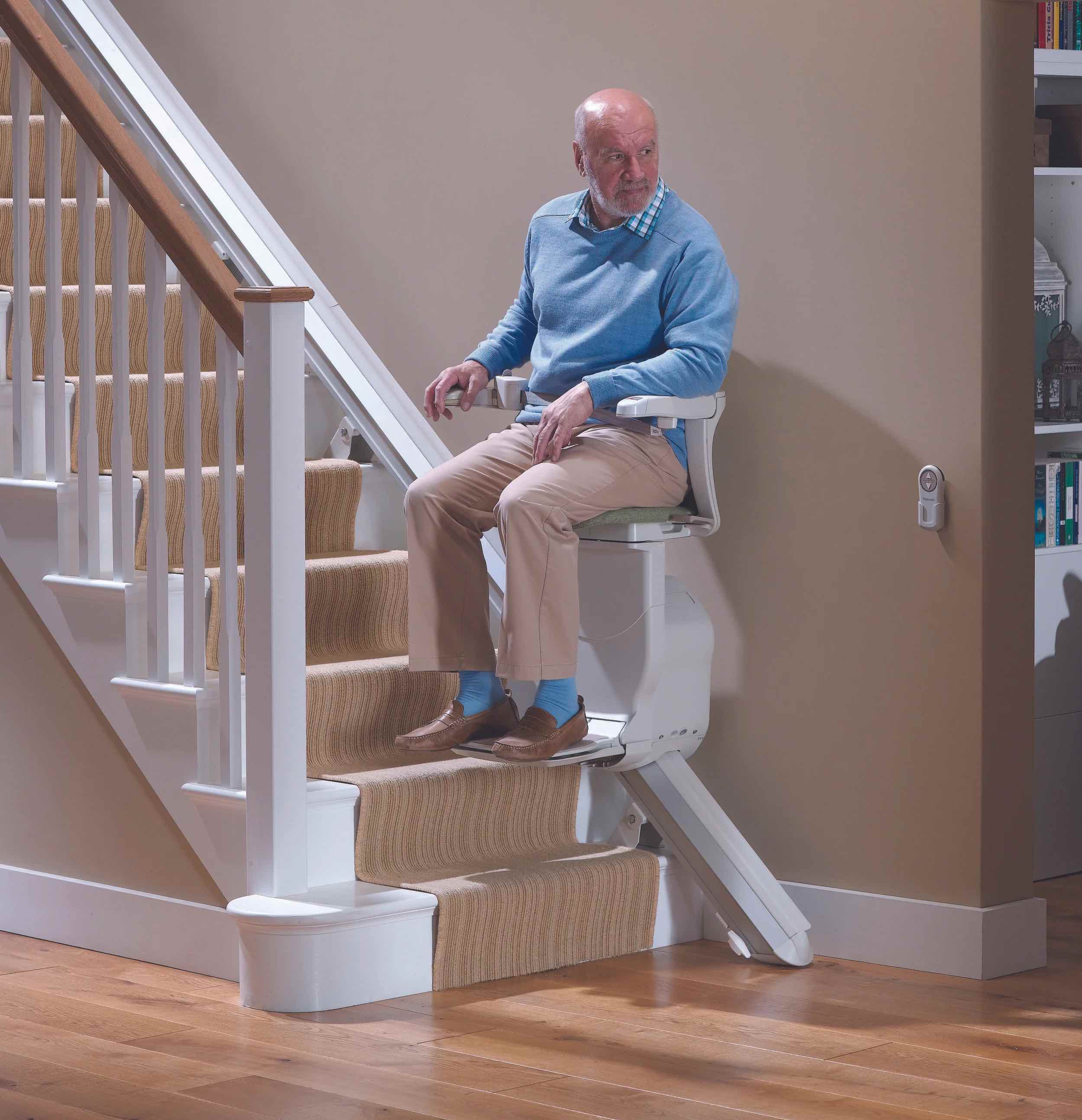 Older man using a straight stairlift in his home
